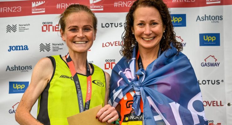 Two women with medals smiling